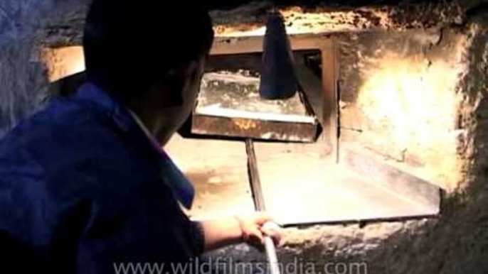 Baker baking fresh bread in oven