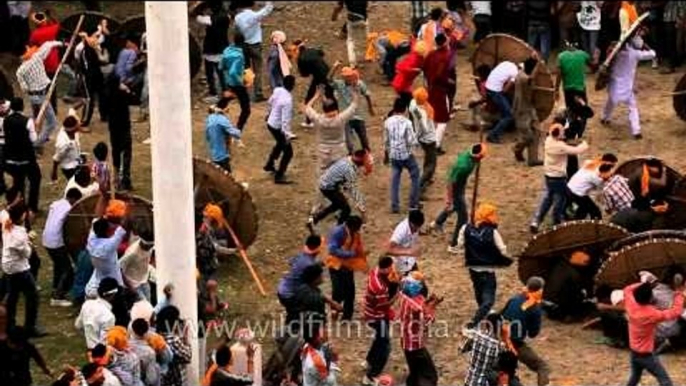 People fighting a battle in front of the temple, throwing stones at each other