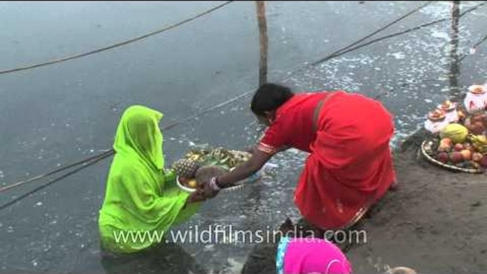 Women perform rituals during Chhath Puja on the banks of River Yamuna