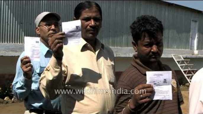 People displaying their voter slips at the voting booth in Lohaghat