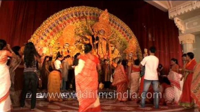 Devotees standing around the idle of Goddess Durga on Durga Puja