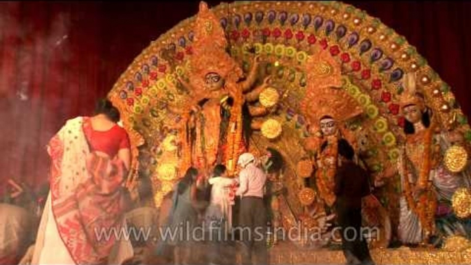 Devotees gather in front of puja pandal to worship Goddess Durga during Durga puja