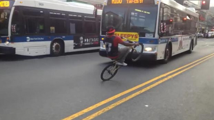 Cycliste sur la roue arrière évite les voitures