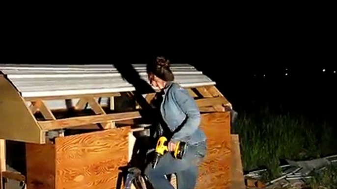 Woman Building a Chicken Coop With Recycled Materials