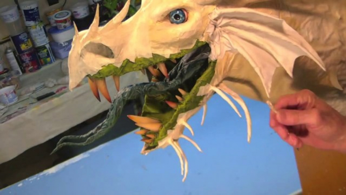 Il fabrique des têtes de dragons en papier mâché