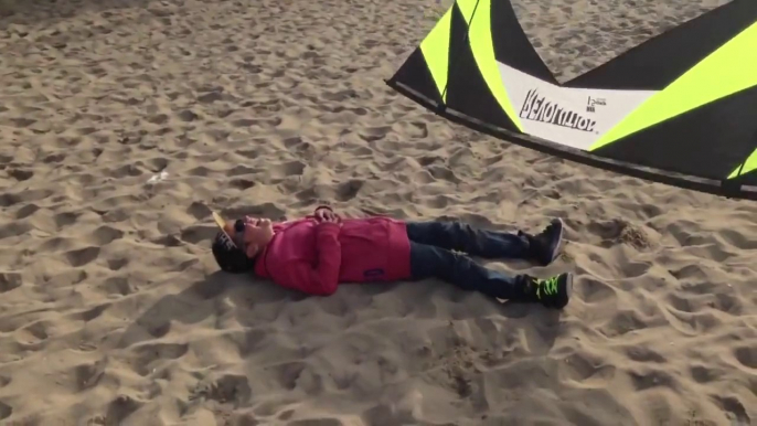 Un enfant joue avec un cerf-volant sur la plage