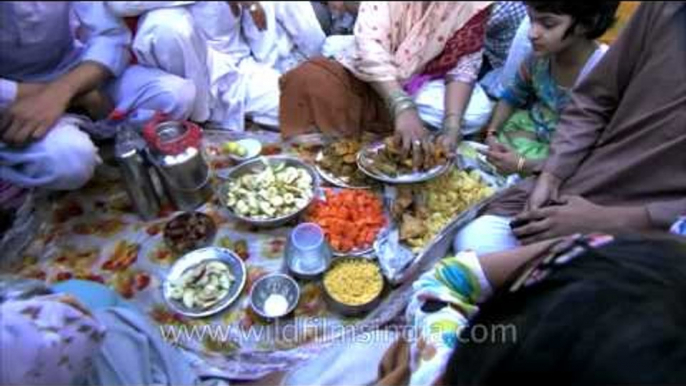 Indian Muslim family place food items on plates during Iftar