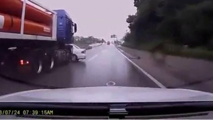 Un automobiliste distrait fini sous un camion. Et le camion ne s’arrête même pas!