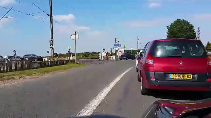 Car drivers crossing a closed rail crossing : crazy