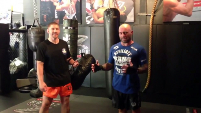 Joe Rogan kicks really hard while Duane "Bang" Ludwig holds pads