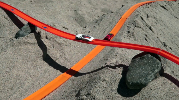 Une course de voitures Hot Wheels sur la plage comme un grand prix de F1