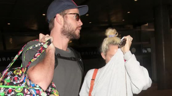 Liam Hemsworth and Miley Cyrus Hold Hands as They Land in LA