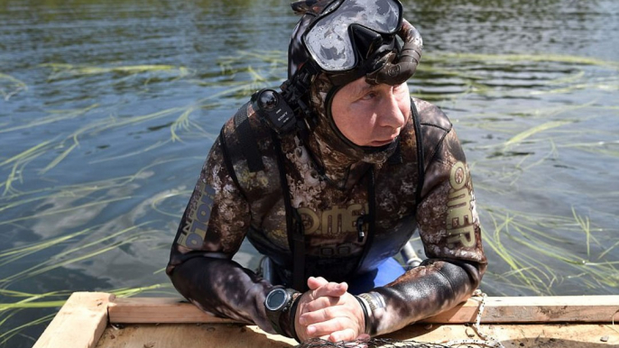 Putin poses for his latest action shots diving and fishing