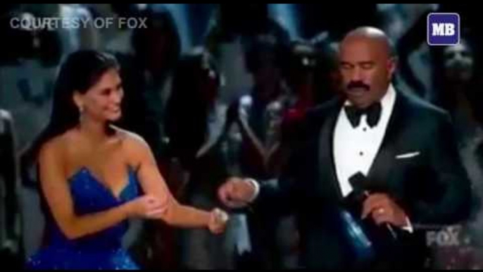 Pia Wurtzbach gives Steve Harvey a pair of eyeglasses before announcing the final result.
