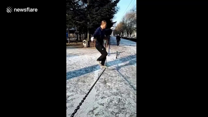 Man performs precarious workout balanced on iron chain