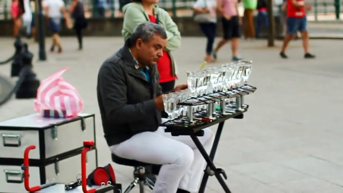 Un homme joue la musique Popcorn avec des verres