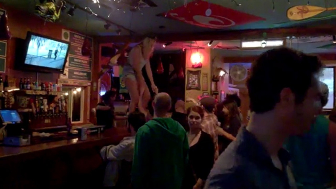 Une femme chute en voulant se mettre debout dans sur le comptoi d'un bar