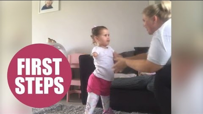 Cute amputee daughter takes first steps on prosthetic legs