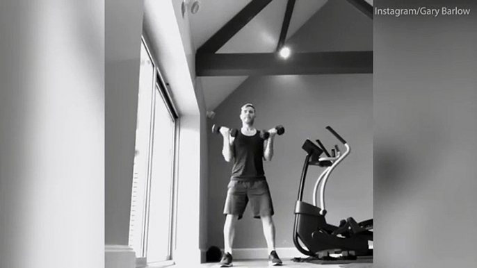 Gary Barlow shows off his exercise routine as he lifts body weights