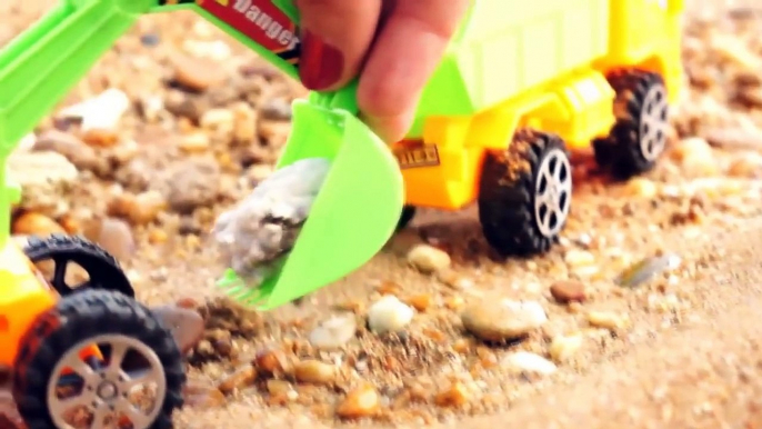 Spielspaß am Meer. Spielzeugautos sammeln am Strand schöne Steine.