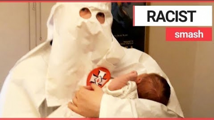 Dad pictured holding his baby dressed in Ku Klux Klan robes | SWNS TV