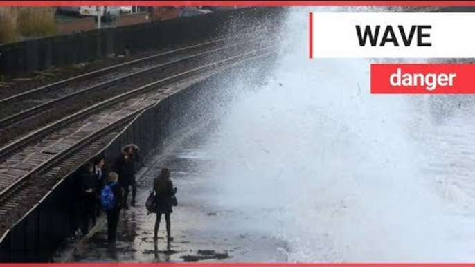 Children risking their lives by dodging huge waves on the wrong side of a seawall | SWNS TV