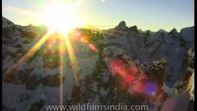 Sun's golden rays sparkling like cosmic glitter in the Himalayas