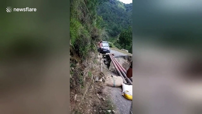 Terrifying moment car crosses damaged mountain road on makeshift track