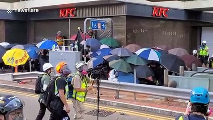 Hong Kong protesters shield themselves from rubber bullets with umbrellas