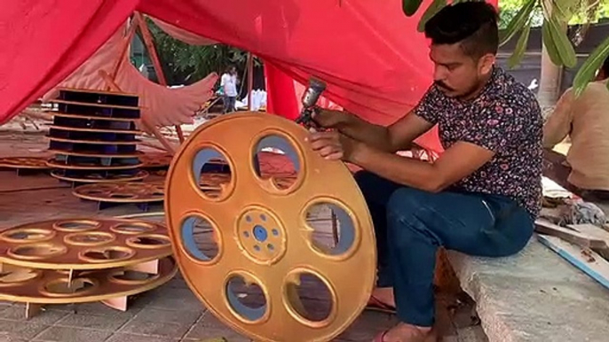 Large cutouts of film reel models get spray painted in gold and jewel blue ahead of IFFI 2019 in Goa.