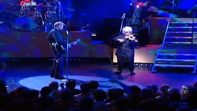 Magie musicale à l'Olympia : Johnny Hallyday et Catherine Lara nous transportent avec 'Quelque Chose de Tennessee' en 2000, une performance envoûtante où le violon sublime l'émotion sur scène.