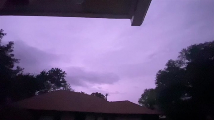 Dark clouds loom as lightning flashes over city