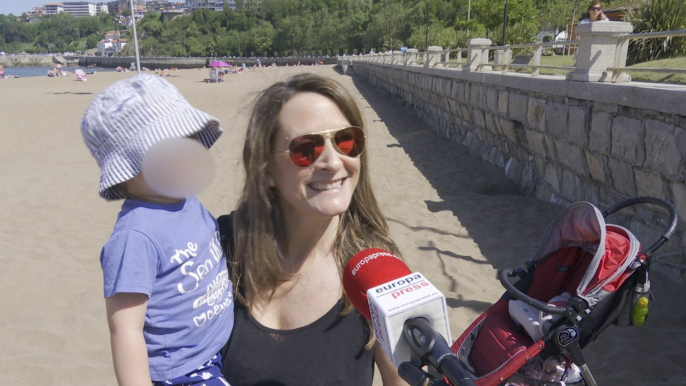 Madre contenta con hijo en la playa tras haber estado "confinados en terrazas"