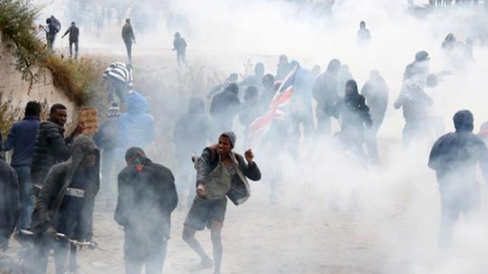 Police clash with migrants and protesters outside France's Calais migrant camp