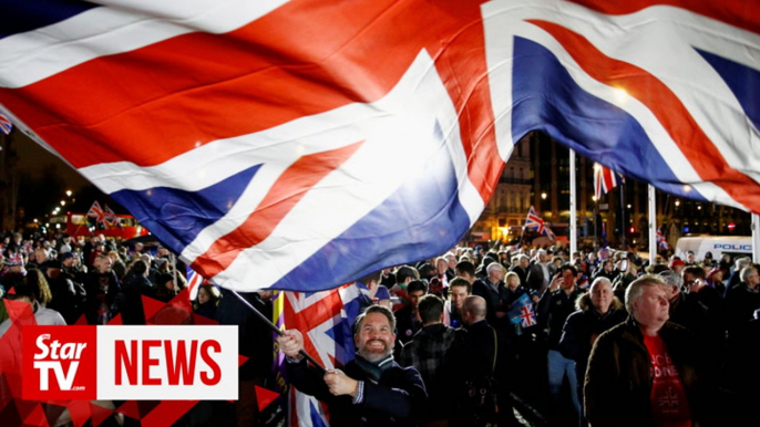 Brexit Day revelers with balloons and flags waving in Parliament Square