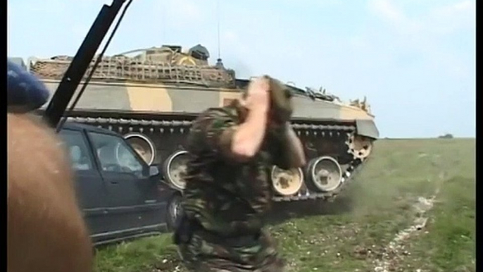 Ce caméraman venu filmer une démonstration de char d'assaut va repartir à pied... voiture écrasée