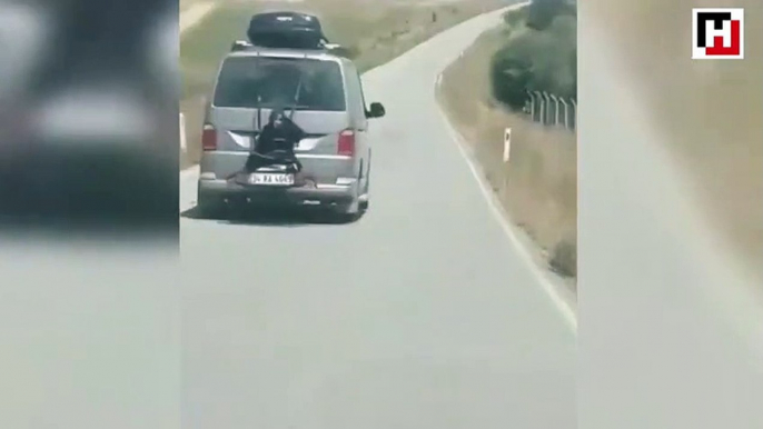 Driver slammed for carrying passenger tied on back of car