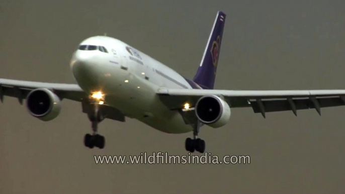 Thai Air and Air Asia planes come in to land at Bangkok airport