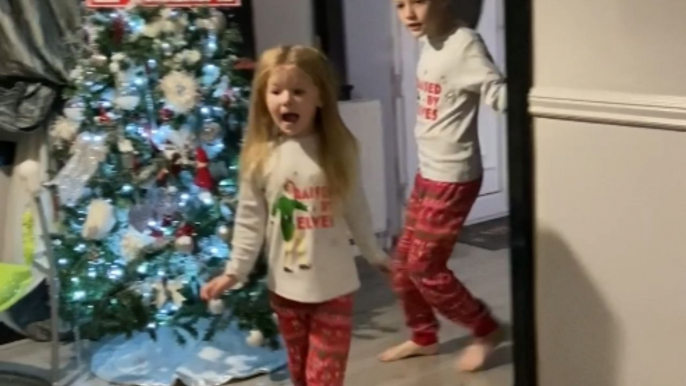 Children wholesomely react on receiving Christmas presents from parents