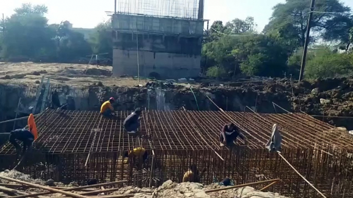 An iron net is being woven to erect the structure of the bridge being built at the railway gate.