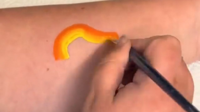 Forearm turns into a canvas as artist creates an eye-catching dinosaur design with face paints