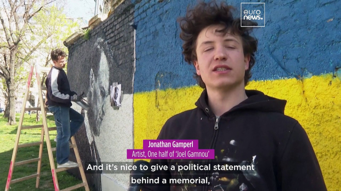 Artists spray-paint portraits of Alexei Navalny behind a Soviet monument in Vienna