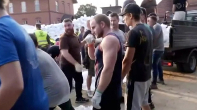 Volunteers create human chain to distribute sandbags along Poland river during severe flooding