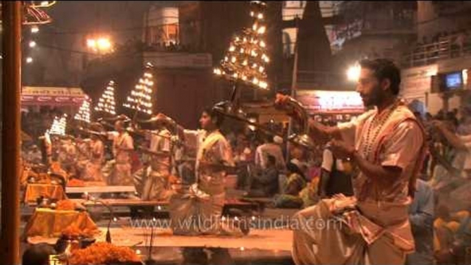 Hindu priests holding lit up Multi-tiered aartis during Ganga Aarti, Varanasi