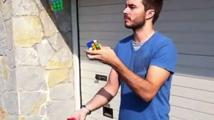 A man juggles and solves Rubiks Cubes