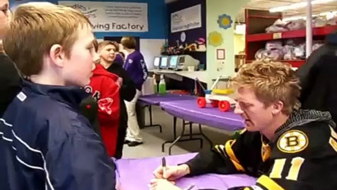 Boston Bruins player  P.J.  Axelsson celebrates with Quincy students