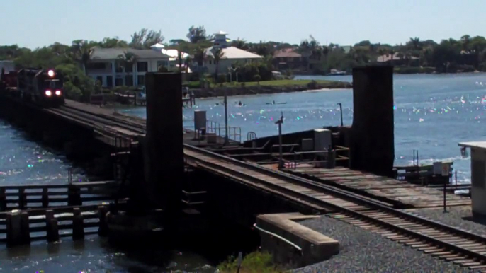 FEC Train 240 with oversized flatcar, generator, and caboose.