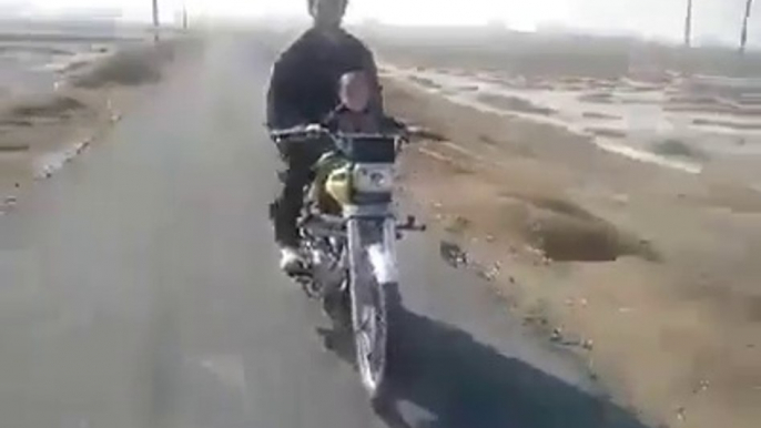 A 2 year old baby riding a bike in Pakistan - Very Dangerous