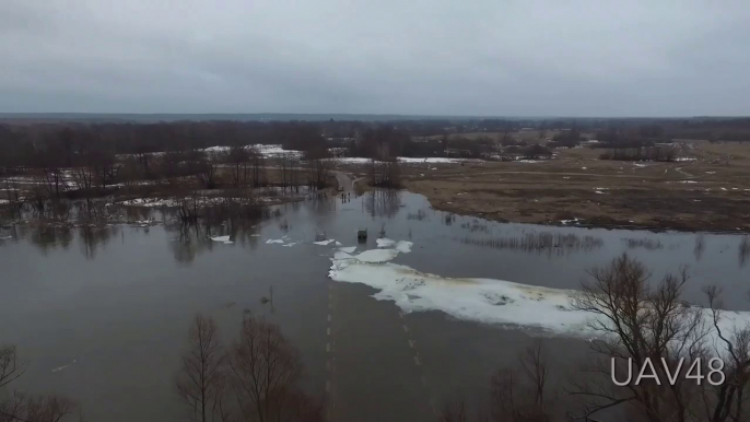 Tractor Clears Ice Floes From A Flooded Bridge