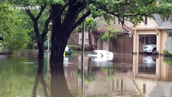 People canoe through flooded residential area during Houston floods